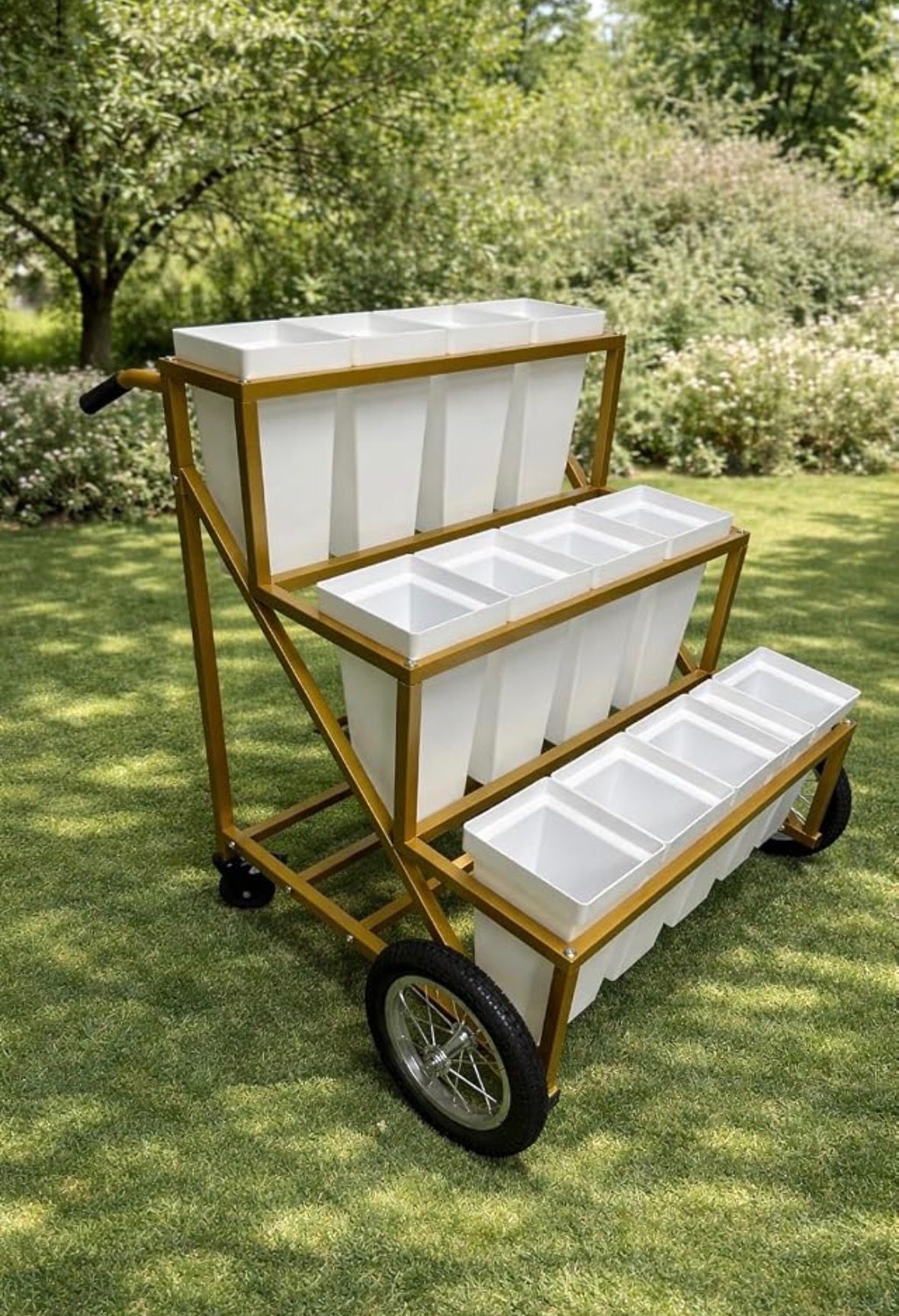 Three-tier gold Bloom Bar cart with white flower bins, standing on grass